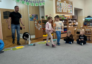 Pies idzie za dziećmi ustawionymi w parze.