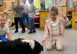 Pies szuka karmy schowanej przez dzieci.