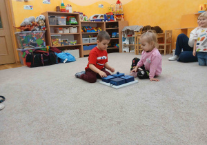 Przedszkolaki chowają smaczki dla psa.