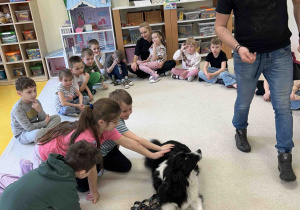 Dzieci głaszczą pieska.