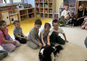 Dzieci głaszczą pieska.