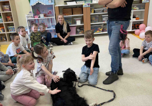 Dzieci głaszczą pieska.