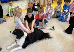 Dzieci głaszczą pieska.