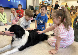 Dzieci głaszczą pieska.
