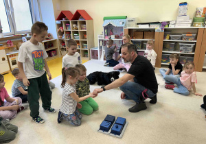 Dzieci chowają smaczki do pudełka.