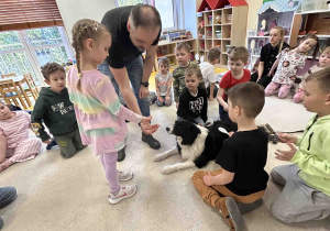 Dzieci czeszą pieska.