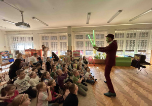 Magik pokazuje sztuczkę ze świecącymi mieczami.