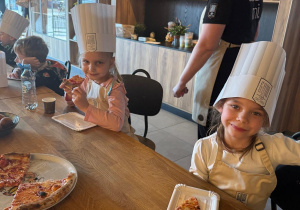 Dziewczynki zjadają pizzę.