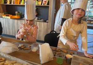 Dzieci przyozdabiają ciasteczka.