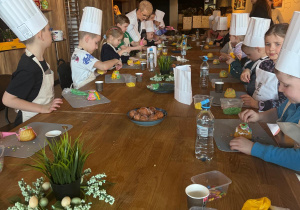 Dzieci ozdabiają wielkanocne babeczki.