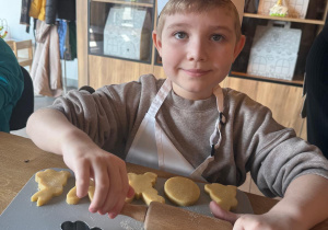 Chłopiec wałkuje ciasto.