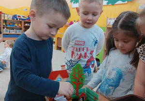 09. Chłopiec wkłada ziarenka roślin do ziemi.