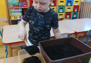 16. Chłopiec sieje nasiona roślin.