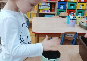 20. Dziewczynka sadzi rośliny.