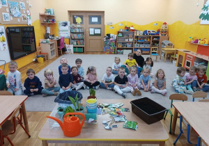 21. Dzieci siedzą na dywanie.