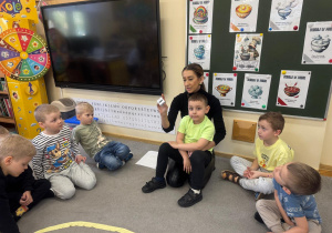 Nauczyciel prezentuje kostkę do gry.