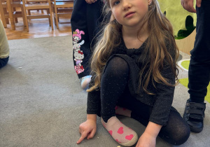 Dziewczynka pokazuje swoją literkę.