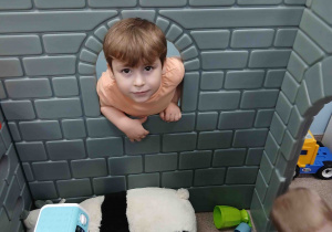 Chłopiec wygląda przez okno w zamku.