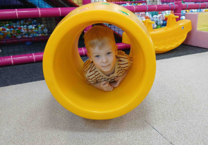 Chłopiec bawi się w beczce.