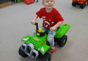 Chłopiec jedzie autkiem.