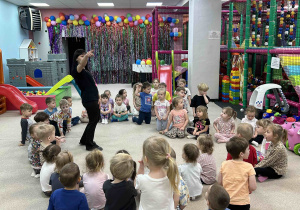 Dzieci siedzą w kole.