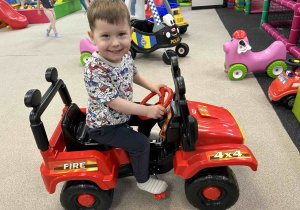 Chłopiec jedzie autkiem.