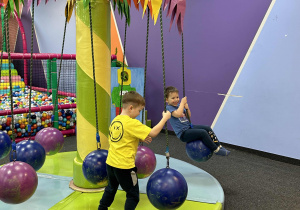 Dziecko bawi się na karuzeli.