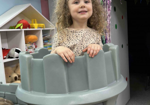 Dziewczynka stoi na wieży zamku.