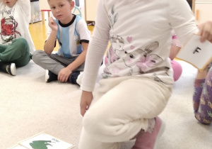 14.Dziewczynka dopasowuje literę do ilustracji.