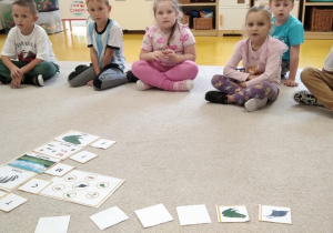 15.Sześciolatki siedzą na dywanie.