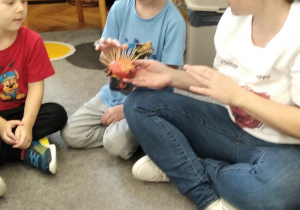 06.Dzieci dotykają jeża zrobionego z jabłka i wykałaczek.