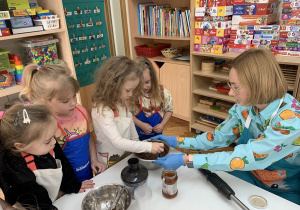 Dziewczynka dodaje do nutelli miód.