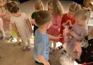 Chłopiec wręcza prezent koleżance z grupy.