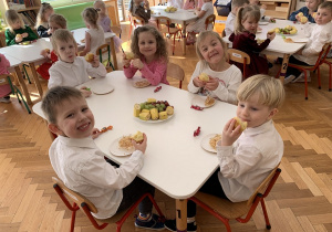 Dzieci przy stoliku podczas poczęstunku.