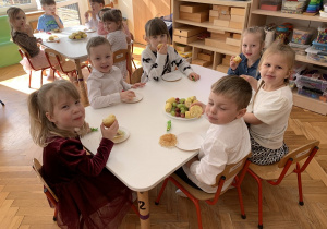 Kropelki jedzą babeczki i owoce.