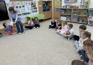 Dziewczynka przygląda się pokazywanej książce.