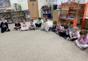 Czterolatki w skupieniu słuchają bajki czytanej przez panią Paulinę.