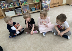 Chłopiec ogląda książkę przyniesioną z biblioteki.