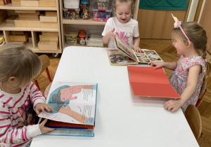 Dziewczynki przy stoliku z książkami.