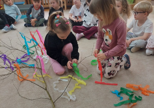 Dziewczynki tworzą Gaiki z kolorowej bibuły.