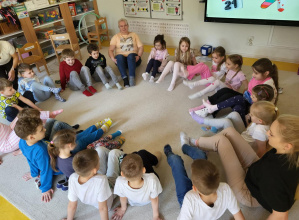 Dzieci siedzą w kole prezentując kolorowe skarpety