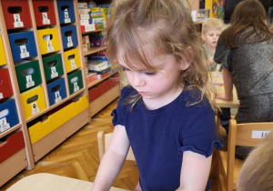 Dziewczynka ozdabia skarpetkę drucikiem kreatywnym..