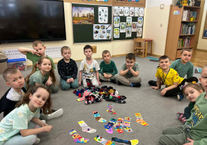 Dzieci siedzą w kole przy kolorowych skarpetkach.