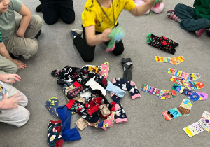 Chłopiec szuka skarpetek do pary.