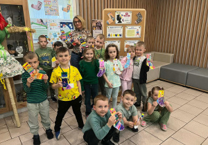 Dzieci pozują do zdjęcia z panią psycholog i skarpetkami wykonanymi przez siebie.