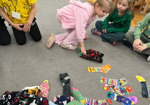 Dziewczynka odkłada odszukaną przez siebie parę skarpetek.