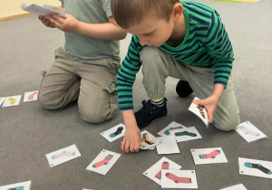 Chłopcy szukają takich samych skarpetek na obrazkach.