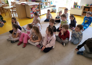 Dzieci z zaciekawieniem oglądają film edukacyjny.