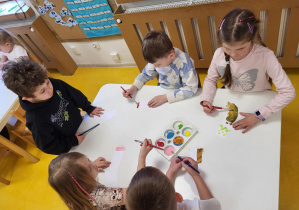 Dzieci malują skarpetki.