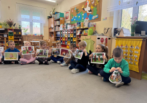 Dzieci trzymają ilustracje pasujące do opowiadania.